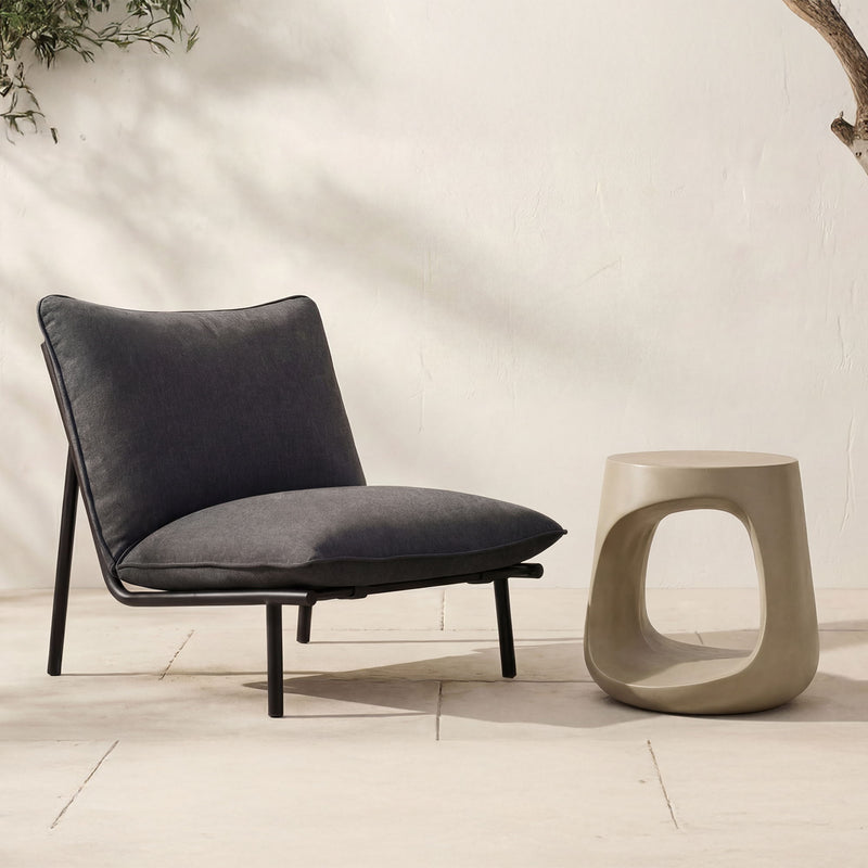 Cream sculptural outdoor stool with oval cutout opening, tapered sides and flat top.