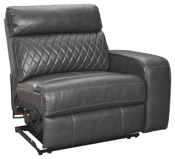 Gray power recliner seat with diamond-quilted back, padded arms, and exposed power hardware