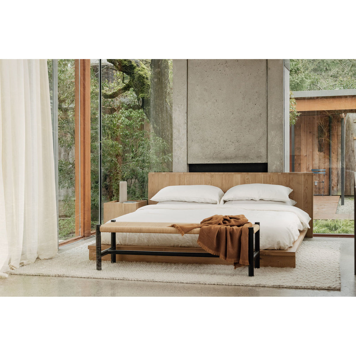 Natural oak king bed with curved slatted headboard, white pillows and duvet