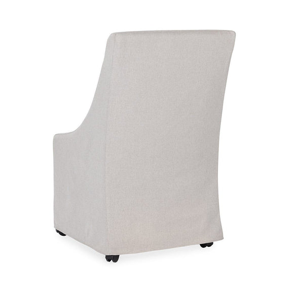 Upholstered rolling dining chair in light beige fabric, side view with casters