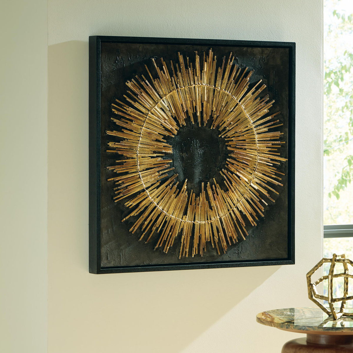 Black framed wall art with gold sunburst rod circle on dark square panel