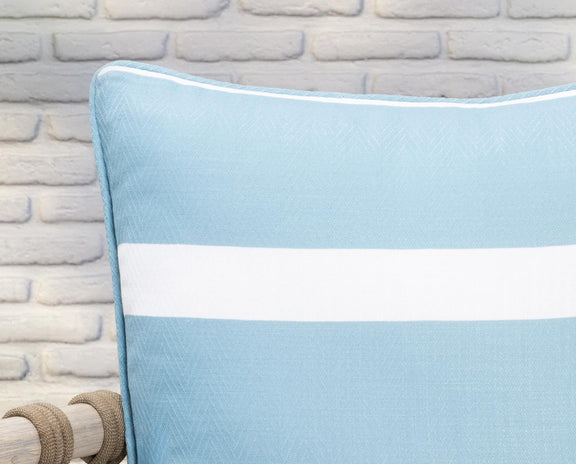 Blue striped throw pillow close-up with white band and piped edge