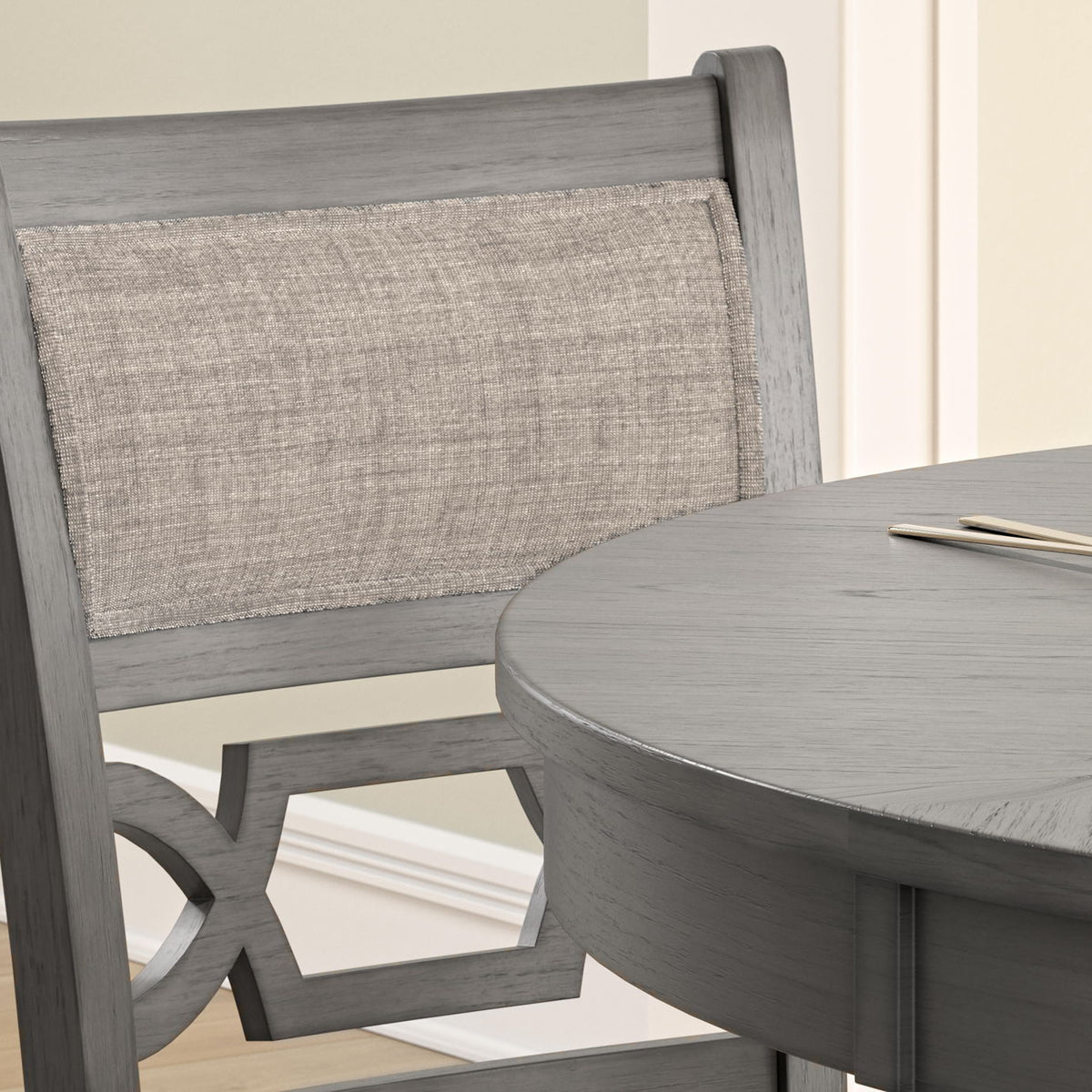 Gray counter table with round top and fabric-back stool detail