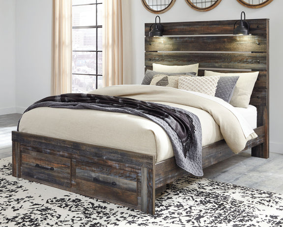 Drystan panel bed with dark wood headboard, two front drawers, and layered neutral bedding.
