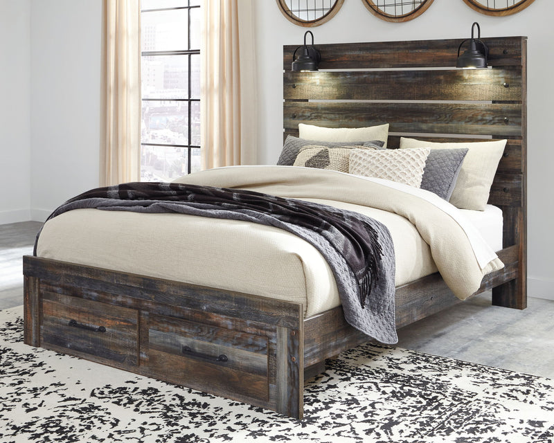 Drystan panel bed with dark wood headboard, two front drawers, and layered neutral bedding.