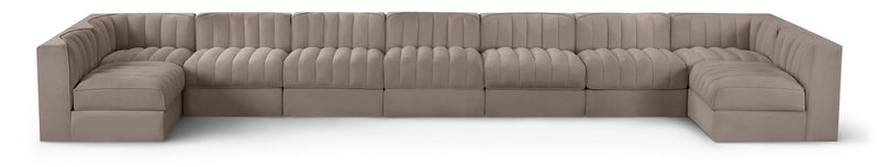 Light beige velvet modular sectional sofa with tufted cushions and curved armrests