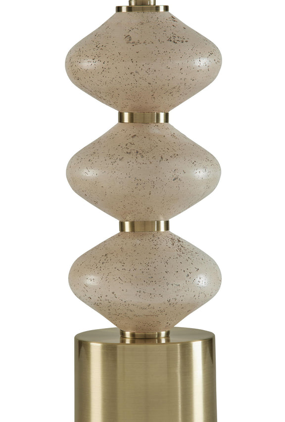 Close-up of stacked speckled beige lamp body with brass top and base