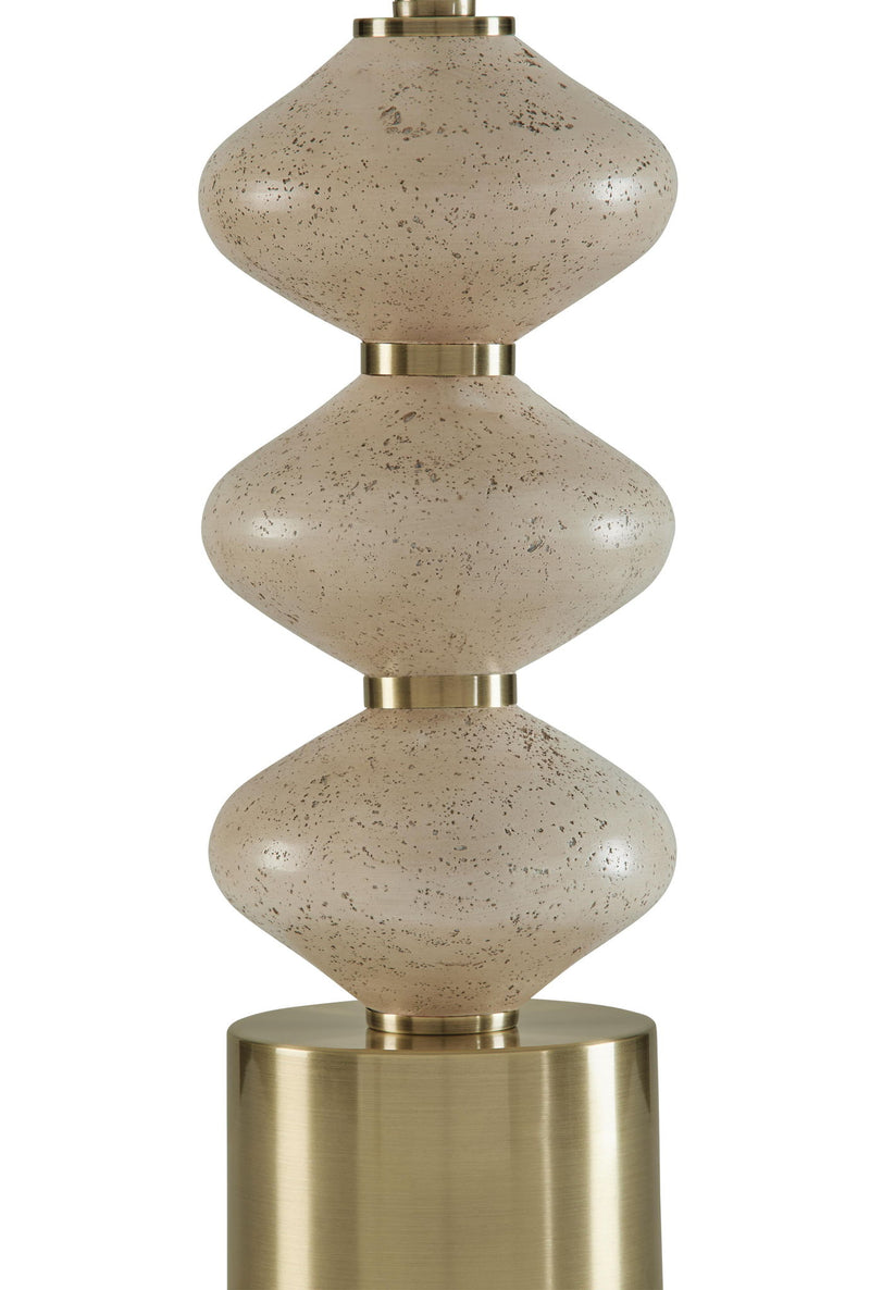 Close-up of stacked speckled beige lamp body with brass top and base