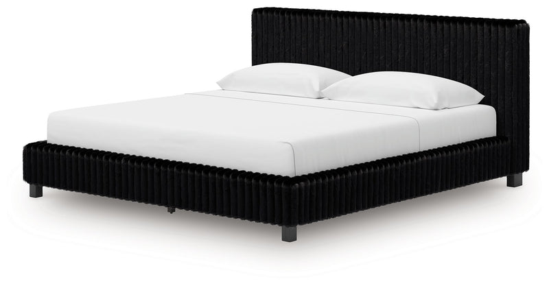 Black upholstered bed frame with ribbed rails, tall headboard, and white bedding.