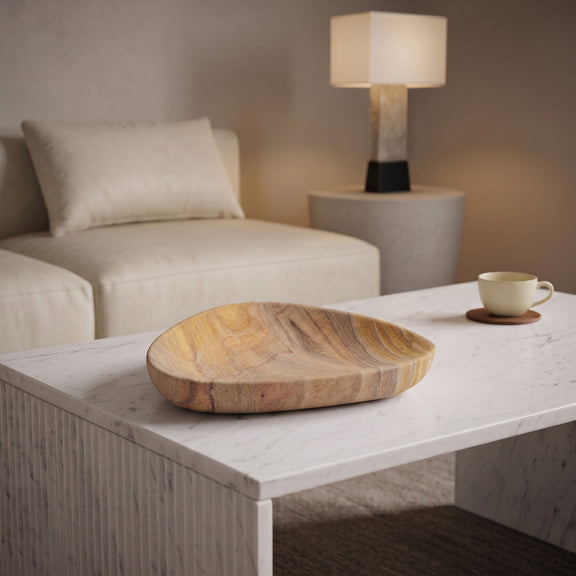 Sandstone bowl on a white table, oval shape with tan and brown veined pattern.