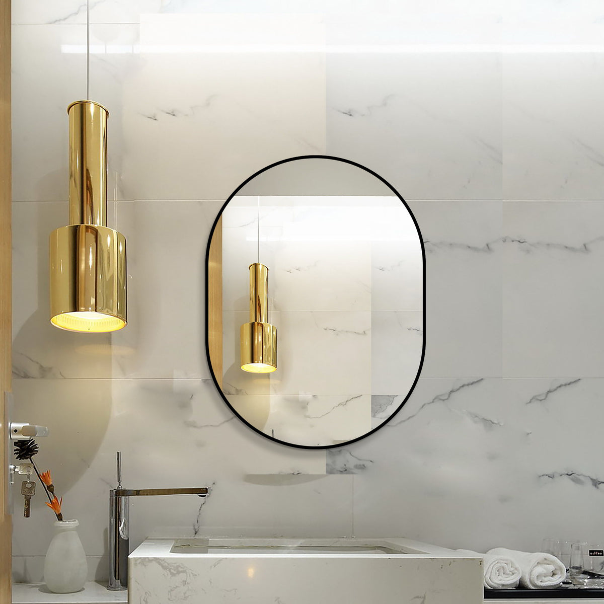 Black-framed oval bathroom mirror with reflective surface on tiled wall