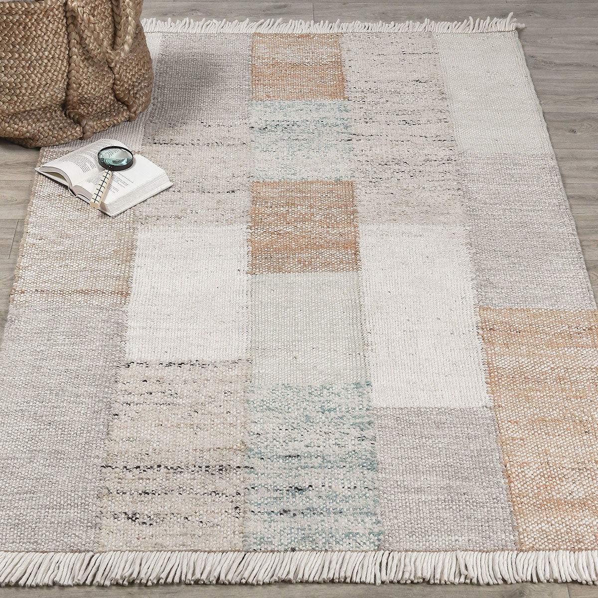 Ritsa rug close-up of patchwork squares in beige and cream with white fringe along border