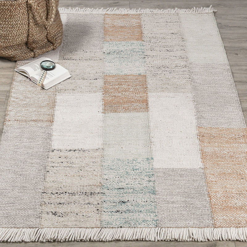 Ritsa rug close-up of patchwork squares in beige and cream with white fringe along border