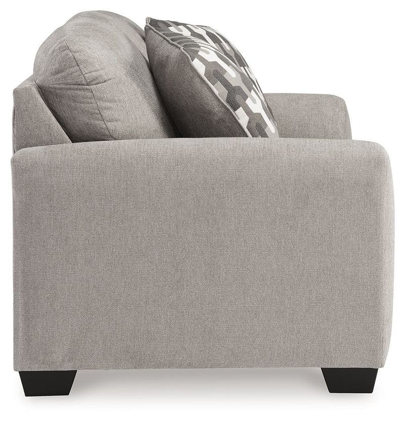 Gray flannel loveseat side view with patterned throw pillow and wide arms