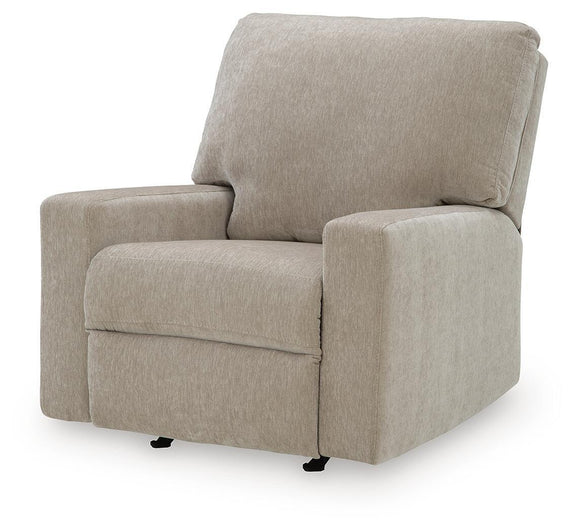 Beige fabric rocker recliner with wide seat, padded backrest, and side arms.