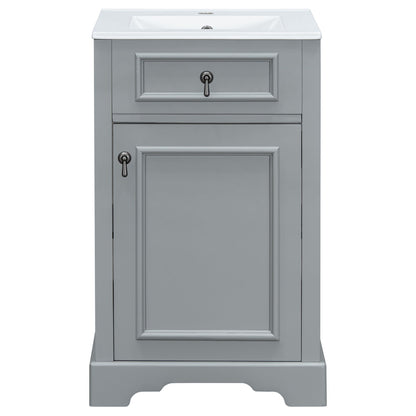 Gray bathroom vanity with ceramic sink and raised-panel cabinet door.