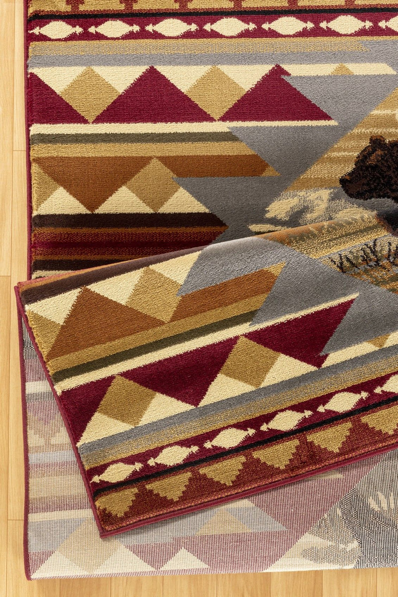 Rectangular lodge area rug with red, cream, and gray geometric pattern and bear silhouettes