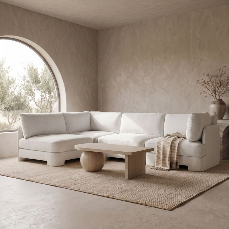 White velvet armless sectional sofa with rounded arms and tufted back cushions