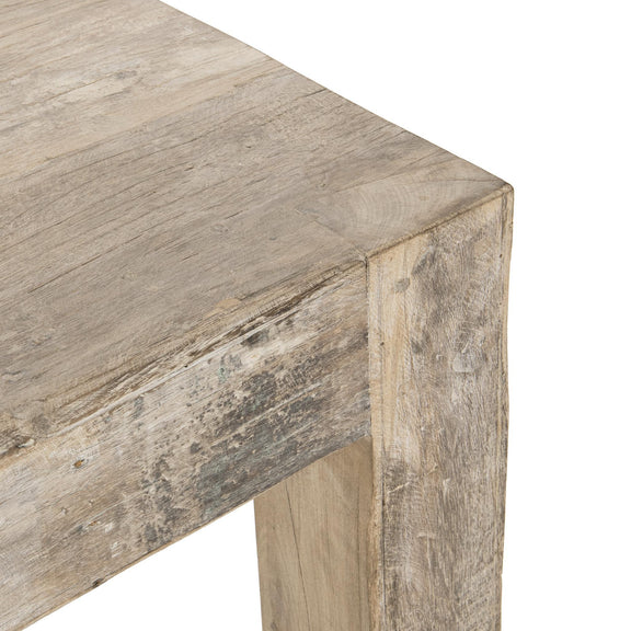 Natural wood table corner detail with visible grain and chamfered edge
