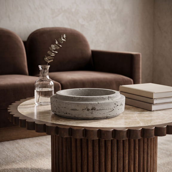 Speckled travertine bowl with shallow round basin and natural mottling