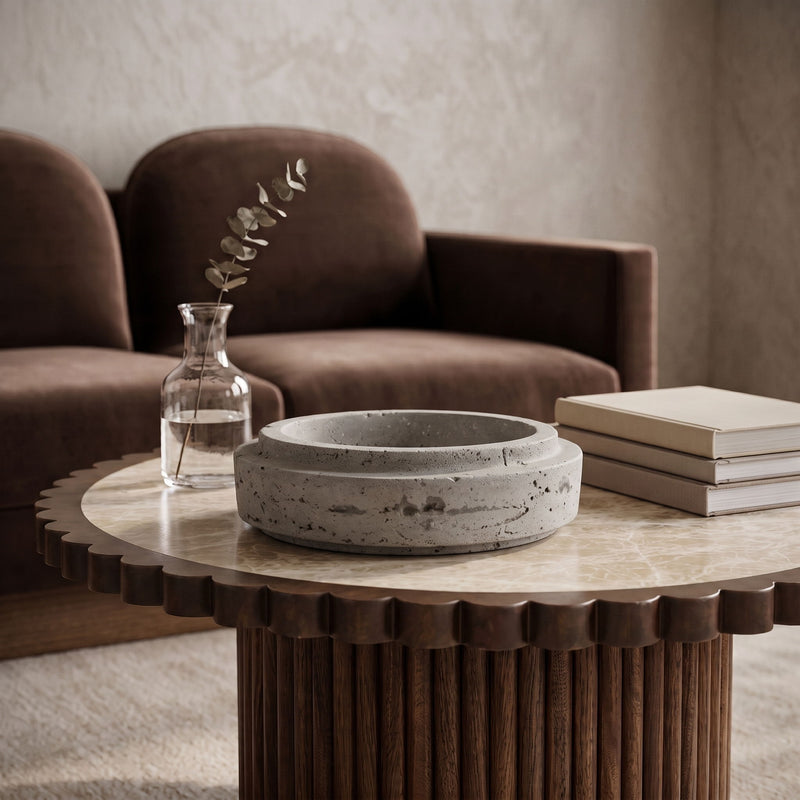 Speckled travertine bowl with shallow round basin and natural mottling