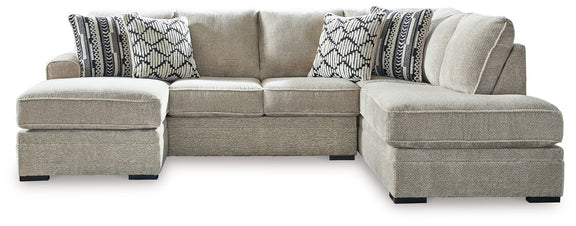 Beige corner chaise sectional sofa with chaise ottoman and patterned throw pillows
