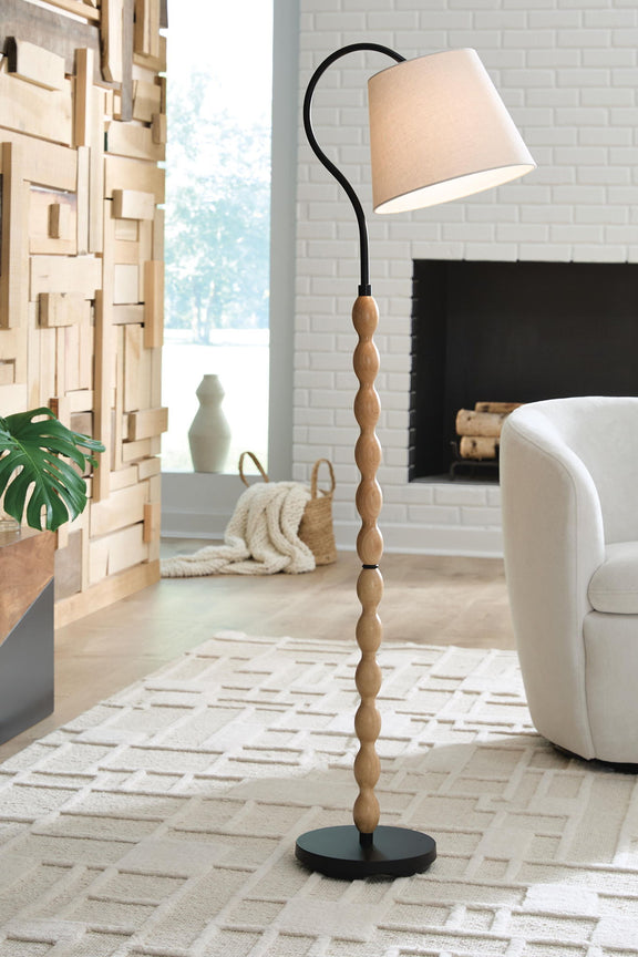 Brown wood floor lamp with black curved stand, beige drum shade, round base