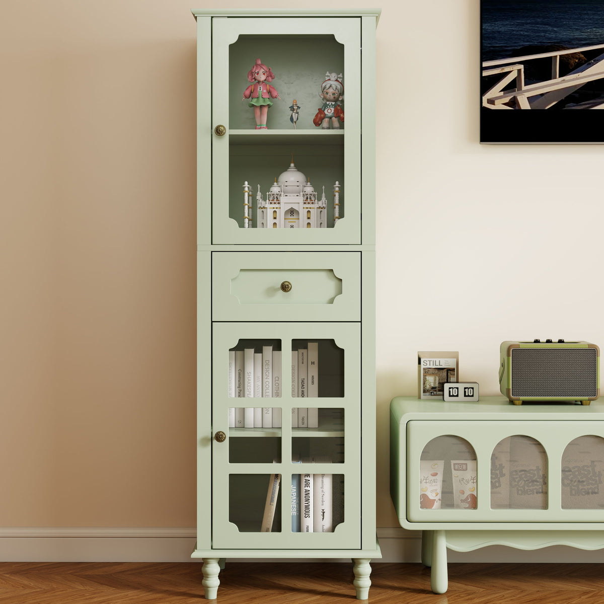 Freestanding green cabinet with upper display shelves, lower glass doors and a central drawer