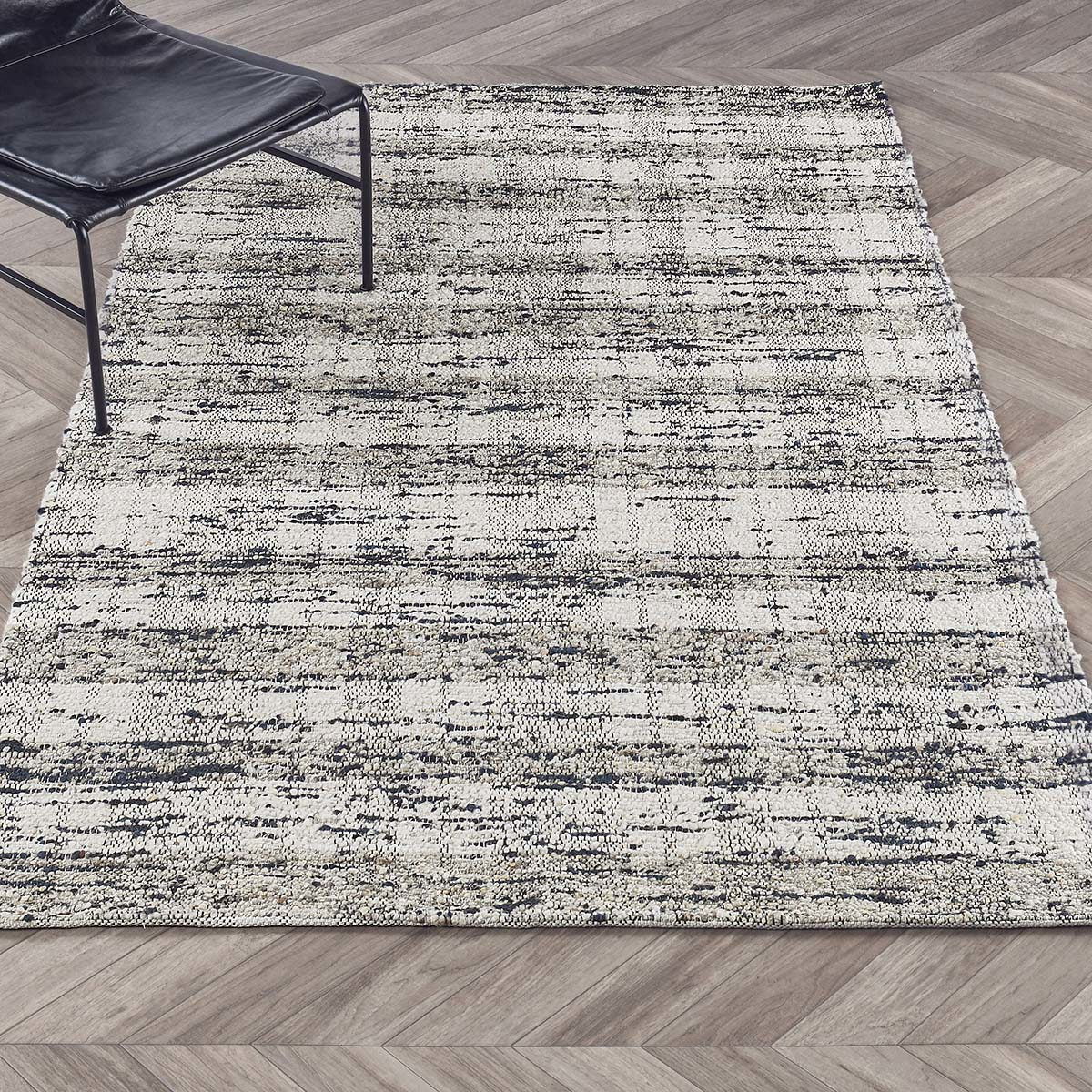 Textured abstract area rug, ivory with speckled blue lines, laid flat