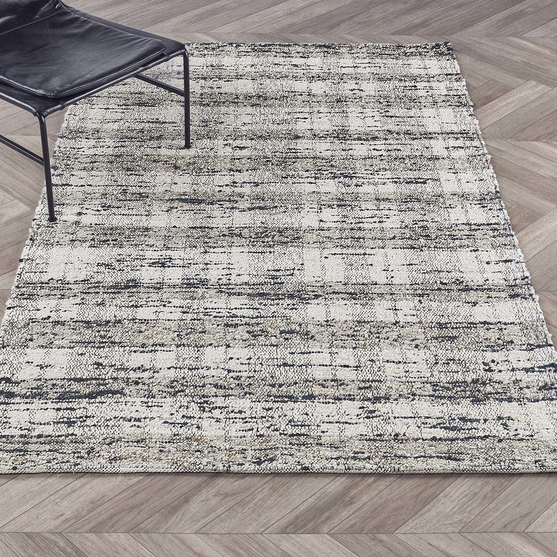 Textured abstract area rug, ivory with speckled blue lines, laid flat