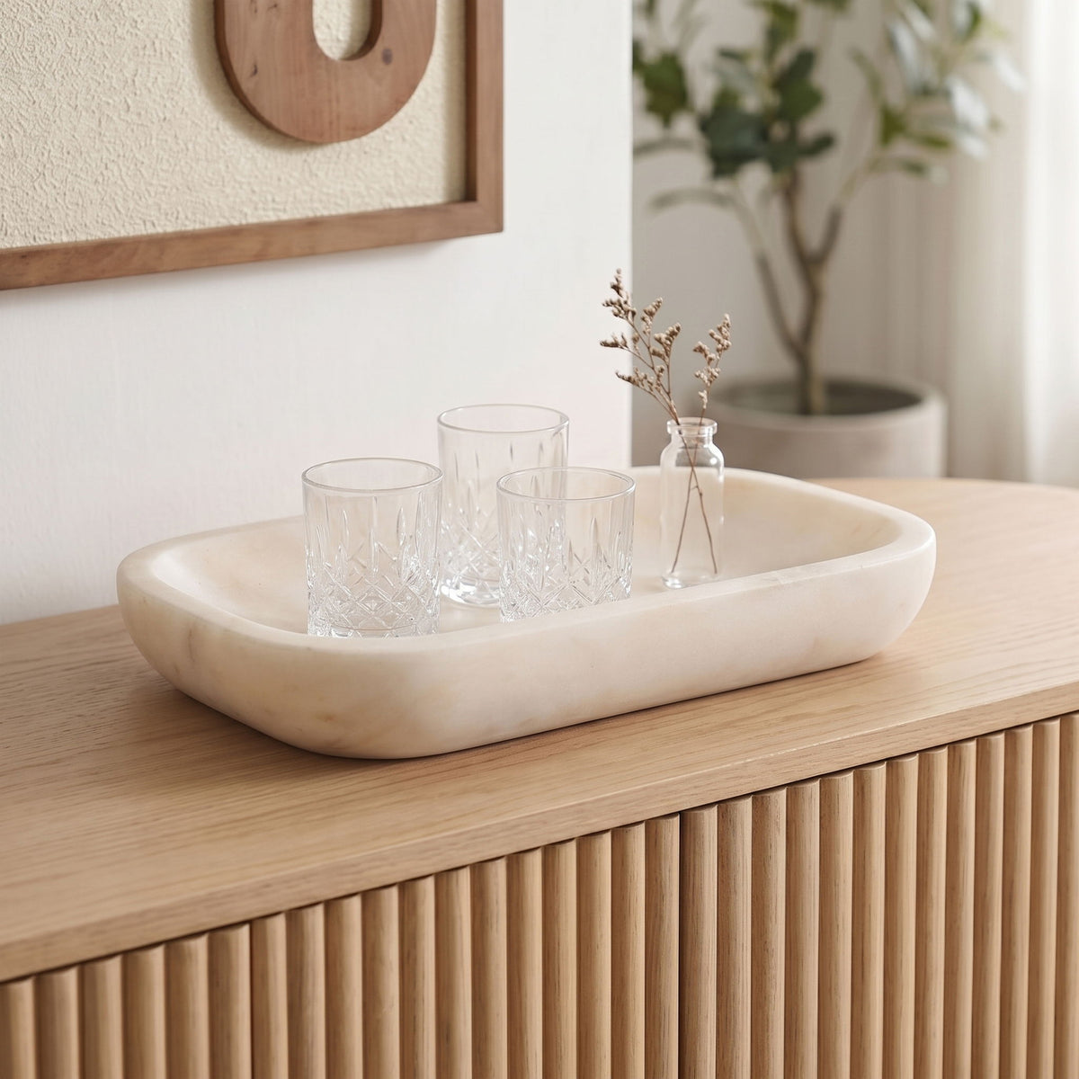 Marble tray on wooden table holding clear drinking glasses