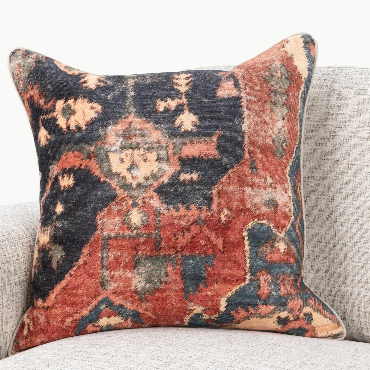 22" x 22" decorative pillow with multi-color abstract pattern, on a sofa
