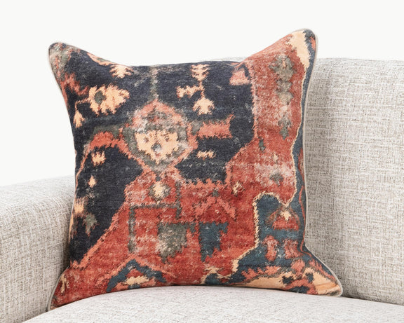 22" x 22" decorative pillow with multi-color abstract pattern, on a sofa