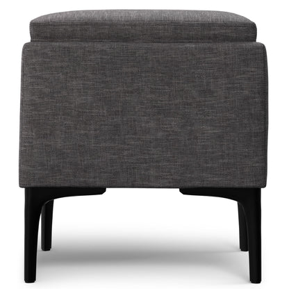 Dark gray fabric storage ottoman with hinged tray top and black tapered legs.