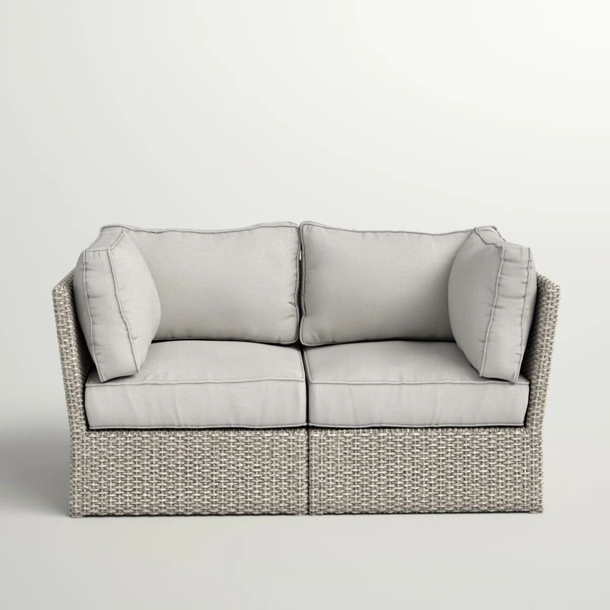 Gray wicker loveseat with light gray seat and back cushions, two bolster pillows
