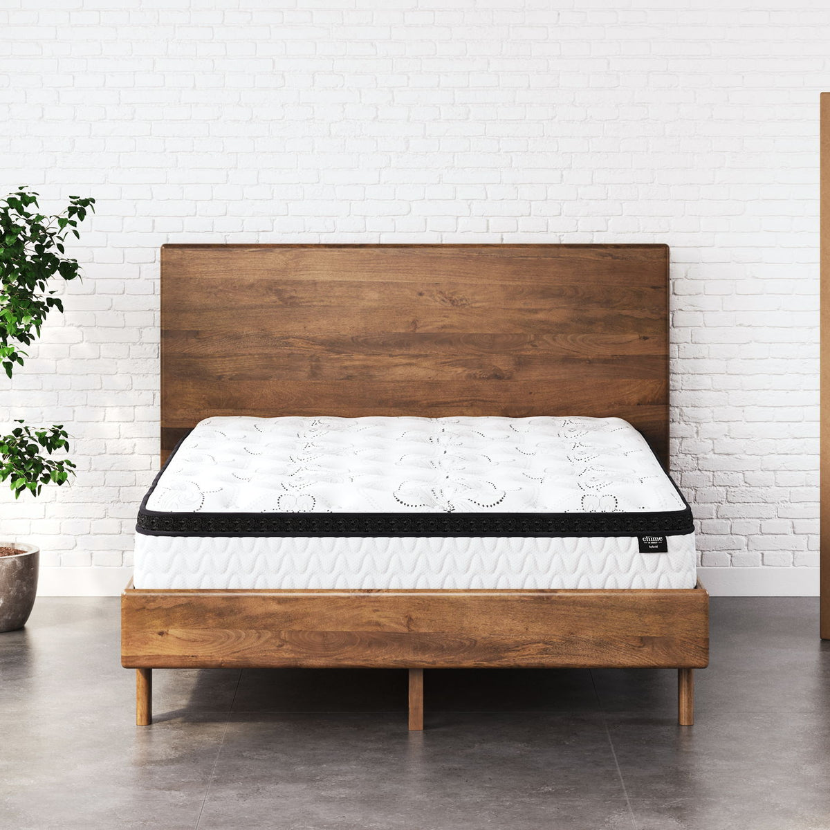 White 12-inch hybrid mattress on wooden bed frame, quilted top with black edge