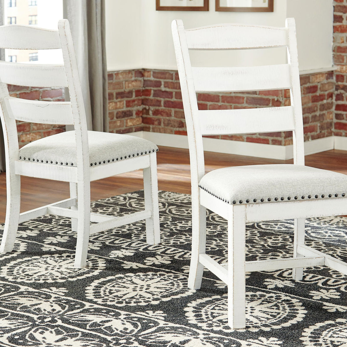 Pair of beige-upholstered dining side chairs with ladder backs and nailhead trim