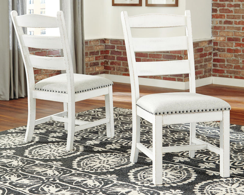 Pair of beige-upholstered dining side chairs with ladder backs and nailhead trim
