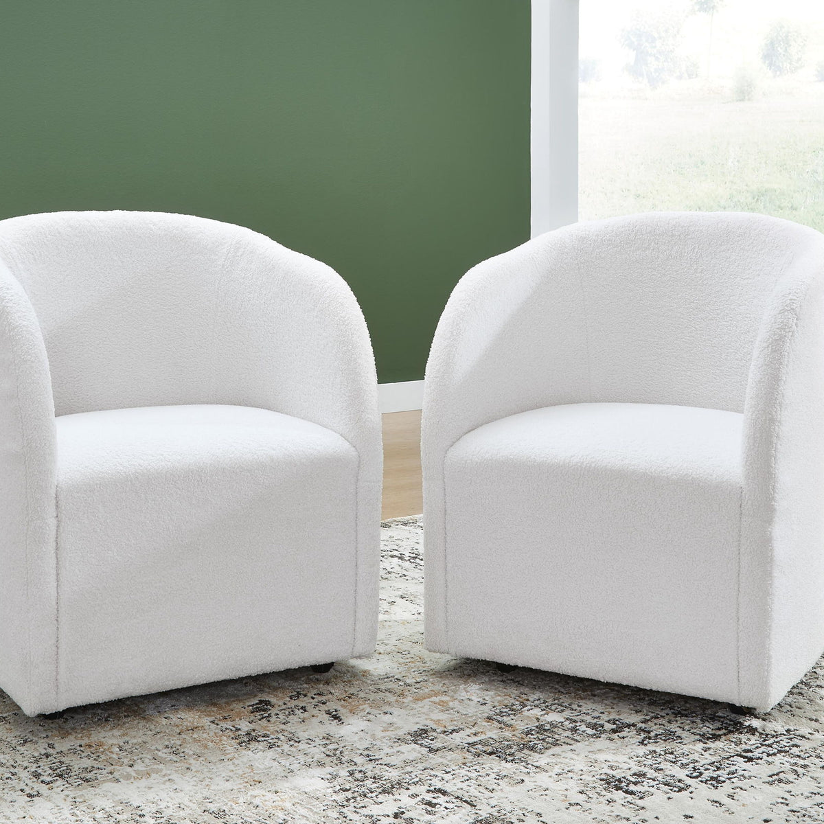 Set of 2 ivory upholstered dining armchairs with curved arms, padded seats, and dark feet