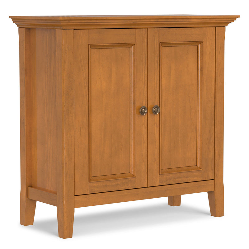 Light brown low storage cabinet with two paneled doors and round metal knob pulls