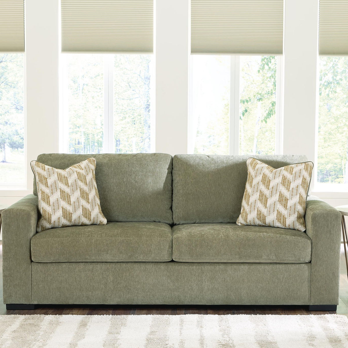 Bridgepoint sofa in green fabric with two seat cushions and two patterned throw pillows