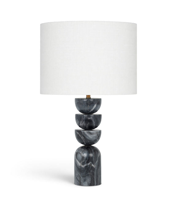 Table lamp with stacked dark marble base and white fabric drum shade, brass accents