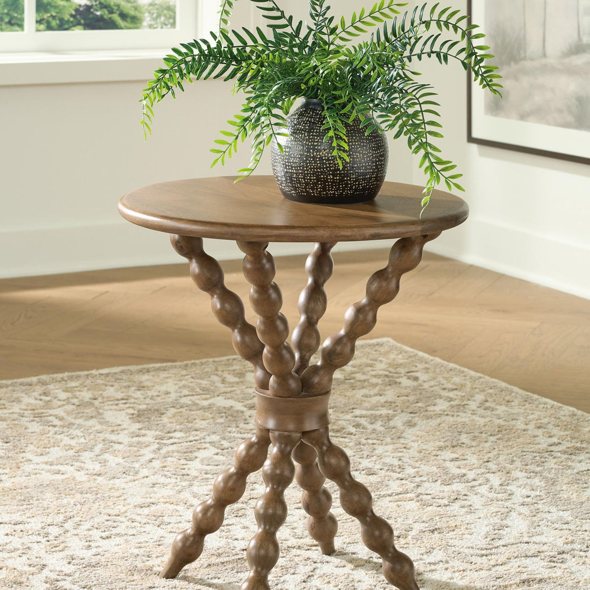 Light brown round accent table with curved trestle legs