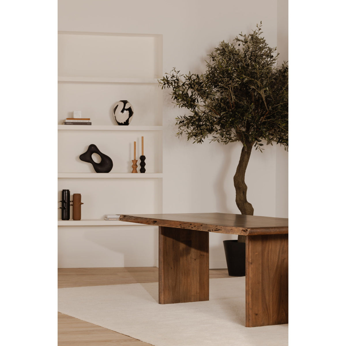 Small dining table with live-edge brown tabletop and wooden legs, side view