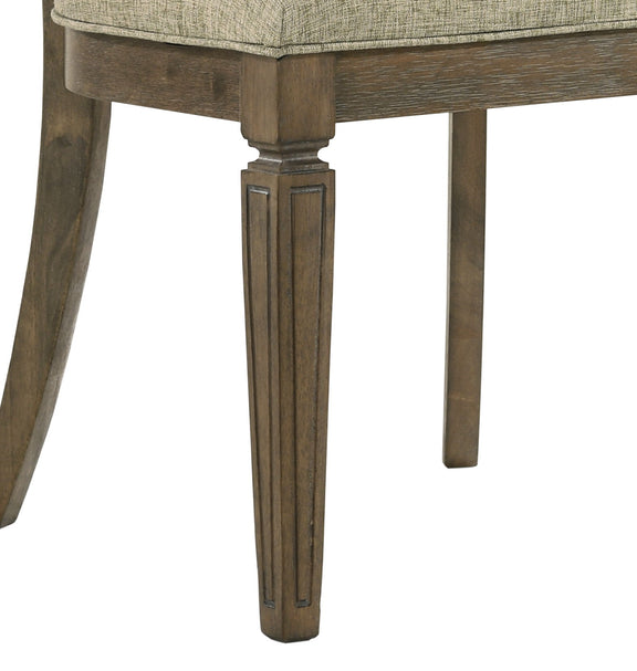 Upholstered dining chair seat with light brown oak legs and apron detail