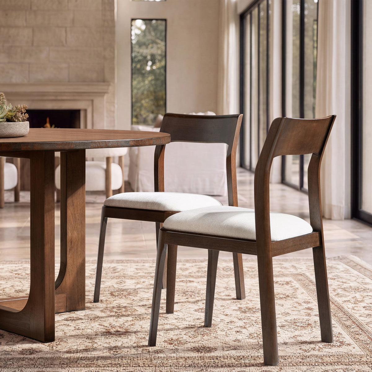 Wood dining chair with curved back and light beige seat cushion