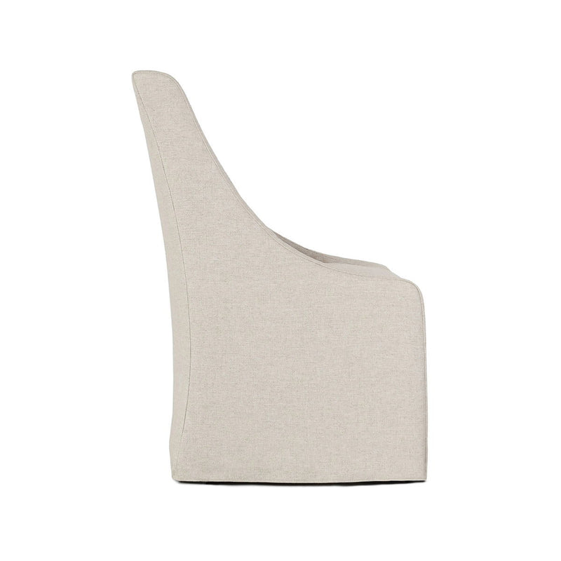 Upholstered rolling dining chair in light beige fabric, angled view showing curved arm