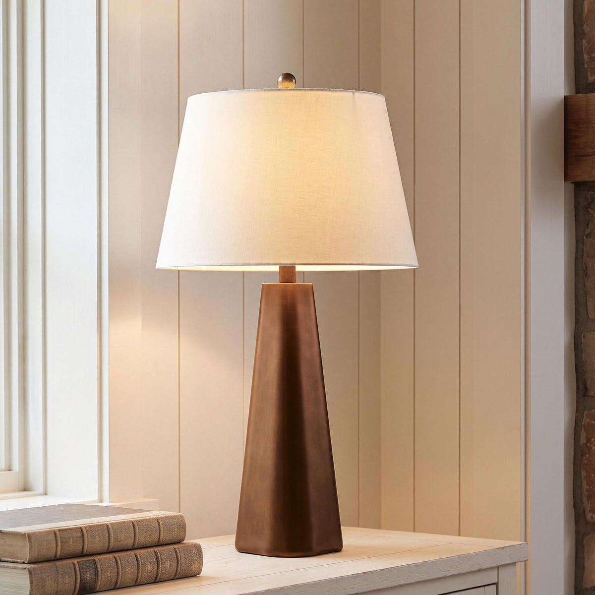 Bronze table lamp with white drum shade and hourglass-style base