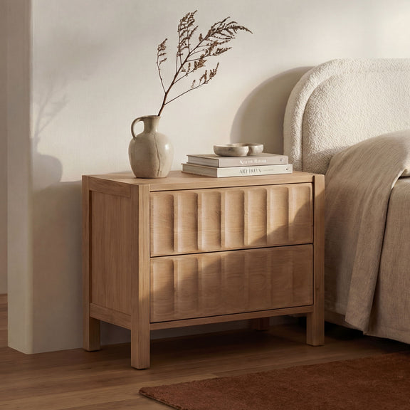 Natural wood nightstand with drawer and cabinet door, tapered legs, side view.