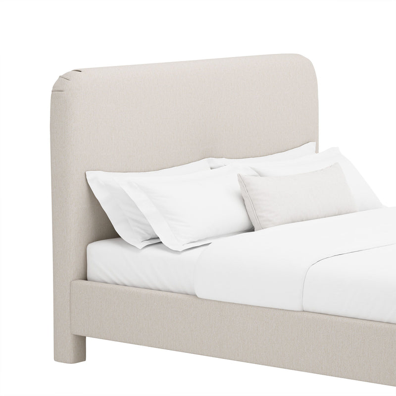 Upholstered bed with rounded headboard and side rails, beige fabric, white bedding